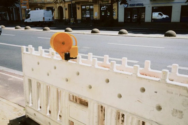 A road barrier with an orange lamp on a Berlin street.