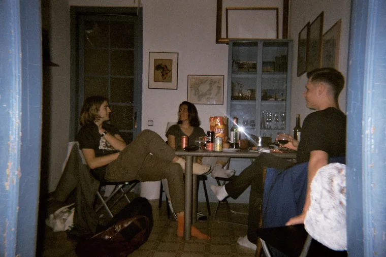 Friends sitting around a table with drinks in a Barcelona flat.