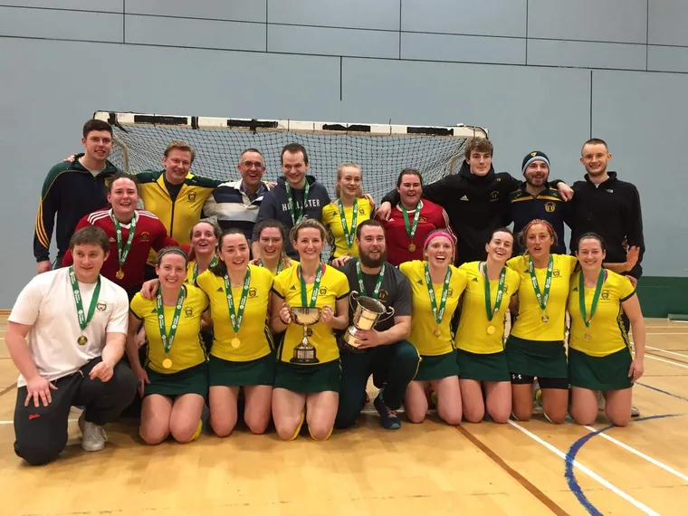 The team celebrating with the trophy and medals after winning the indoor All Ireland.